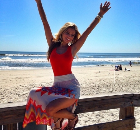 Danielle Knudson Fun day at the beach - sitting on fence, white skirt, bracelets, red tiop, patterned and slit on left side, blonde