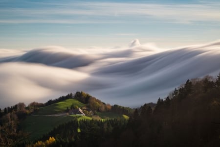 A home sitting atop a lush mountain encircled by soft-serve clouds - clouds, horizon, trees, fog, beautiful, foggy, home, mountain, white, green, mountain home, cloud, mountains, sky