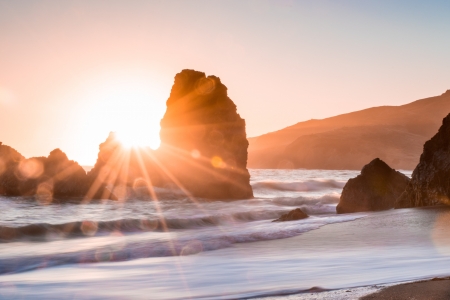 Sunset over some large rocks at a beach - water, coast, golden hour, beach, rock, sea, ocean, spray, surf, sunset, land, sun, rocks