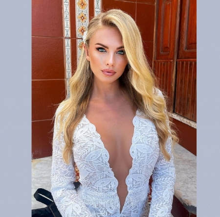 ANET MLCAKOVA - FLOWER IN HER HAIR, SITTING, BLONDE, EARRING, WHITE LACE, PLUNGING CLEAVAGE, LOOKING AT VIEWER