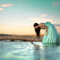 Brunette Posing in Water with a Green Dress