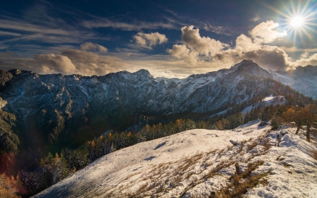 View from the Strelovec peak in the Slovenian Kamnik Savinja Alps - clouds, rocks, sky, snow, trees