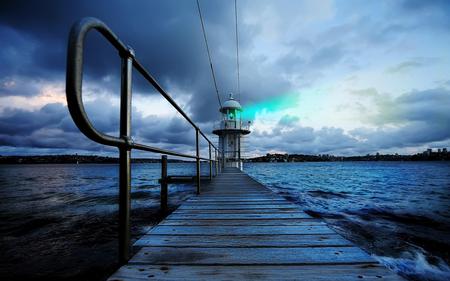 Lighting the dark - greenligh, boardwalk, ocean, lighthouse, clouds, railing, gray