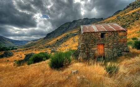 Stoneage house - side of hill, dark sky, old home