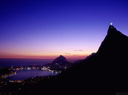 and HE stands above it all - dusk, water, monument, mountain