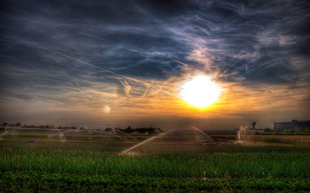 Beautiful Sky - sky, peaceful, sun, water, colorful, field, sunset, clouds, green, sunny, grass, fields, landscape, sprinklers, nature, beautiful, colors