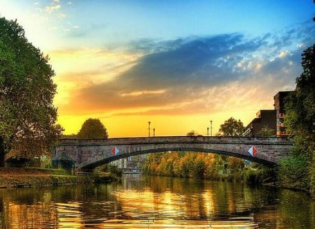 Evening on the golden river - clouds, river, stone, trees, golden reflection, buildings, bridge