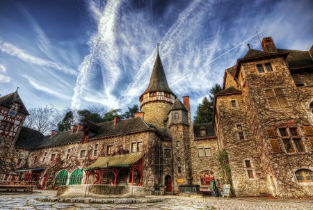 Town square - stone, benches, trees, old buildings, green doors, merchandise, blue sky, canopies