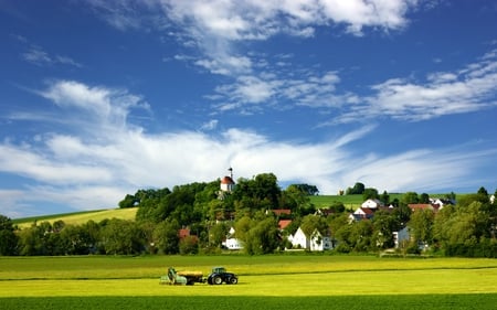 Village - beautiful, village, grass, the work field, architecture, field, machinery, nature, colorful, landscape, beauty, tractor, hills, transport, church, peaceful, sky, town, houses, clouds, fields, landscapes, house, trees, green