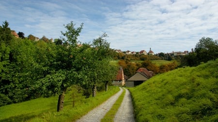 Village - path, road, beauty, beautiful, village, buildings, peaceful, grass, sky, architecture, home, houses, clouds, house, trees, green