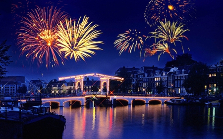 Fireworks - pretty, magic, town, blue, boat, night, light, reflection, holiday, view, fireworks, houses, sky, house, water, happy new year, beautiful, road, beauty, colors, lovely, architecture, buildings, tree, boats, colorful, river, nature, lights, new year, bridge