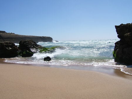 Sea Between Rocks - beach, sky, erosion, water, black, rocks, waves, blue, sand, sea, beige