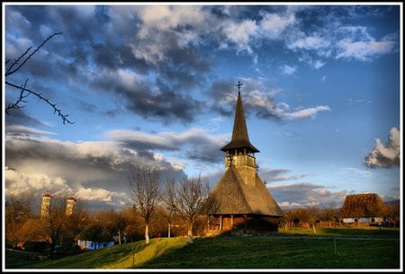 Church - autumn, sky, houses, trees, arhitecture, popular, wood, village, religiuos, brown, church, clouds, blue, green, old, lights