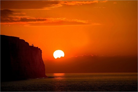 Amber Sun - clouds, firey, water, yellow, sea, ripples, reflection, orange, glow, sunset, dusk, mountains