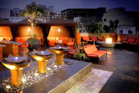 Gorgeous rooftop - stools, tile, cabanas, couch, plants, eooftop, chais, fountains, stones, patio, lights