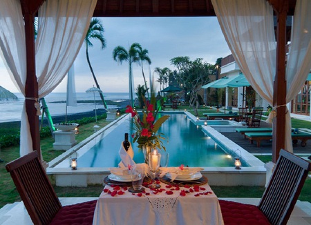 Romantic dinner - trees, candles, chairs, plates, curtain, view, umbrellas, table, romance, rose petals, pool, sea, dinner