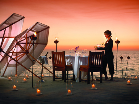 Setting the scene - woman, beach, candles, sunset, chairs, wine, fire, ice bucket, flame, umbrellas, table, romance, wineglasse, sand, dinner, ocean, tablecloth, romantic, winebottle, beautiful