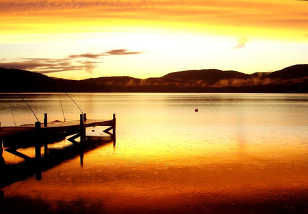 Sunset on the lake - beauty, sky, sun, water, mountains, lakes, brown, amazing, yellow, reflection, glowing, clouds, sunsets, golden, lake, background, landscape, pontoon bridge, gold, nature, glow, beautiful, colors