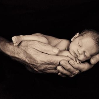 Tiny baby in palms