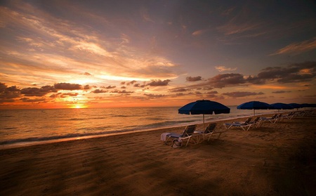 Watching the sunset - clouds, water, beach, beautiful, sunbeams, lounges, ocean, sunchairs, sand, sunrays, sunset, nature, waves, golden, umbrellas