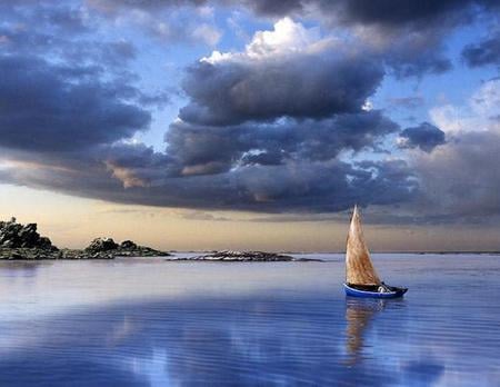 Sail Away - ocean, sail, sky, trees, shore, blue sky, rocks, art, gold sky, clouds, man, sailboat, sea, boat