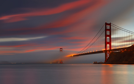 Golden Gate Bridge at dusk - red sky, bridge, cloud of smog, sea