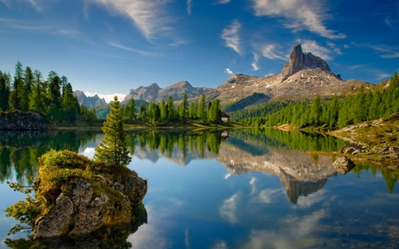 CALM LAKE - hut, cottage, sky, slope, trees, water, clear, mirrored, rocks, crystal, quiet, reflection, calmness, clouds, rock, house, cliffs, hill, lake, mountain, hills, daylight, day, summer, shore, peak, serenity, nature, forest, stones, cabin, pines