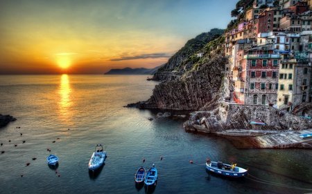 Riomaggiore,Italy - wallpaper, boat, italia, sunset, landscape, peaceful, buildings, coast, sunlight, reflection, clouds, lovely, colors, rocks, beautiful, riomaggiore, amazing, hillside, architecture, view, oceans, tree, nature, colorful, italy, cinque terre, popular, water, rays, beauty, cityscape, sun, sky, houses, new, splendor, house, trees, sea, boats