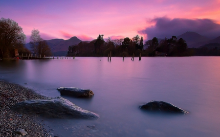 Purple Sunset - rocks, beautiful, cottage, purple sunset, view, pier, tree, nature, mountains, purple, water, evening, landscape, beauty, stones, peaceful, lake, sky, houses, clouds, lovely, splendor, house, trees, colors