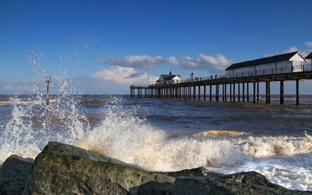 Rough - rock, water, buildings, ocean, deck, blue, white, sky, architecture, wave, clouds, pier