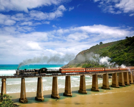 Outeniqua Choo Tjoe Steam Train - beach, cove, sky, ocean, mountain, hills, steam, wave, train, tree, sea, bridge