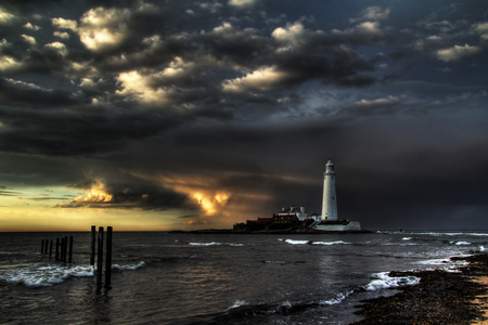 Sentinel Against Dark Skies - ocean, lighthouse, gloomy, water, dark, grey, clouds, island, skies