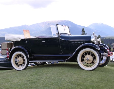 1929 Ford at the Radium Hot Springs car show BC - Canada - nickel, photography, ford, mountains, black, white, headlights, silver, flag, windshields, red, tire, green, tree