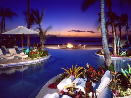 A Vacation in Paradise - evening, chairs, night, flowers, umbrella, fire, palm trees, plants, paradise, towels, clouds, drinks, trees, water, vacation, ocean, sunset, pool