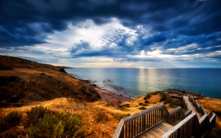 Beautiful Sky and Sea - beauty, sky, beach, peaceful, path, storm, wood, amazing, view, clouds, sunrays, stormy, grass, rays, ocean, sunlight, way, light, lovely, nature, blue, beautiful, splendor, colors, sea