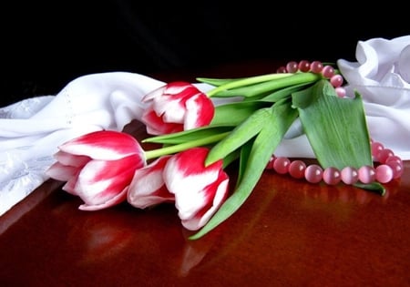 Beautiful and tender - pearls, cloth, beautiful, table, white cloth, beauty, lovely, still life, leaves, flowers, tulips, necklace, white, red, green, tender