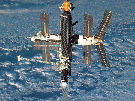 international space station - planet, solar panels, clouds, shadow