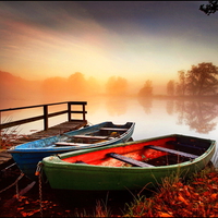 Boats at misty sunrise background