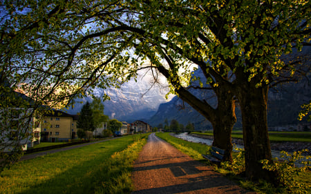 Peaceful Place - stream, road, view, river, spring time, grass, landscape, way, wallpaper, nature, beautiful, alps, leaves, new, switzerland, beauty, valley, sky, trees, peaceful, water, bench, mountains, blue sky, path, clouds, architecture, green, bigs trees, tree, house, bridge, houses, lovely, town, alley, splendor, flowers