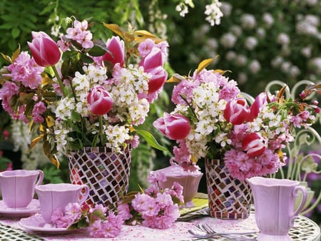 Spring table - cups, spoon, lavender, lilac, spring, flowers, purple, garden, centerpiece, vase, beautiful, table, teacups, lovely, saucer, petals, vases, chair, tulips, nature, glass, colored glass