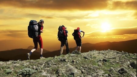 mountain sports - sunset, hikers, backpacks, mountain