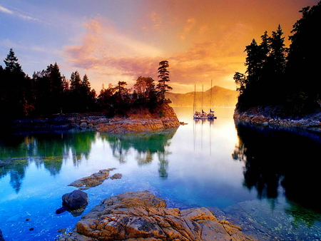 Sailing in calm waters - calm, clouds, water, golden sky, mirrored, reflection, orange, stones, boats, river, glowing, treesm sky, nature, lake, peaceful, rocks